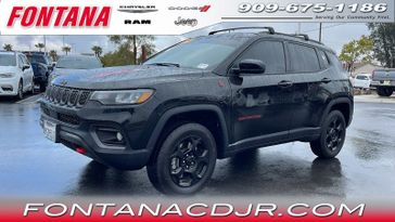 2023 Jeep Compass Trailhawk in a Diamond Black Crystal Pearl Coat exterior color and Ruby Red/Blackinterior. Fontana Chrysler Dodge Jeep RAM (909) 675-1186 fontanacdjr.com 