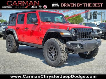 2023 Jeep Wrangler 4-door Willys 4x4 in a Firecracker Red Clear Coat exterior color and Black - A7X9interior. Carman Chrysler Jeep Dodge Ram 302-317-2378 carmanchryslerjeepdodge.com 