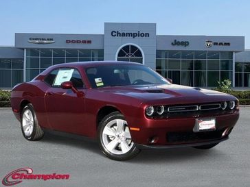 2023 Dodge Challenger SXT in a Octane Red exterior color and HOUNDSTOOTHinterior. Champion Chrysler Jeep Dodge Ram 800-549-1084 pixelmotiondemo.com 