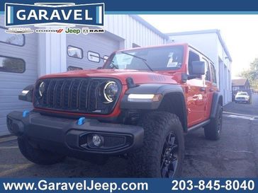 2024 Jeep Wrangler 4-door Willys 4xe in a Firecracker Red Clear Coat exterior color and Blackinterior. Garavel Jeep 475-258-7987 norwalkjeep.com 