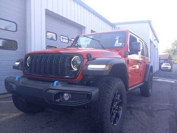 2024 Jeep Wrangler 4-door Willys 4xe in a Firecracker Red Clear Coat exterior color and Blackinterior. Garavel Jeep 475-258-7987 norwalkjeep.com 