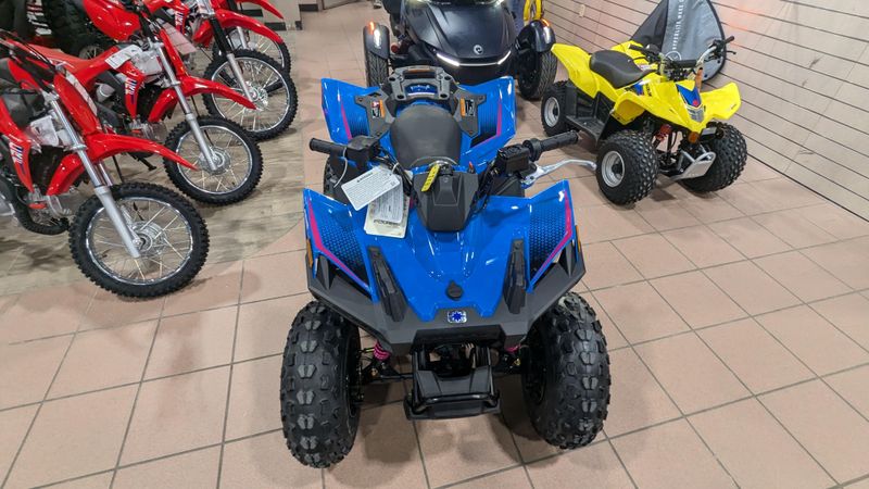 2025 POLARIS OUTLAW 70 EFI  VELOCITY BLUE AND FIERCE FUCHSIA in a VELOCITY BLUE AND FIERCE FUCHSIA exterior color. Family PowerSports (877) 886-1997 familypowersports.com 