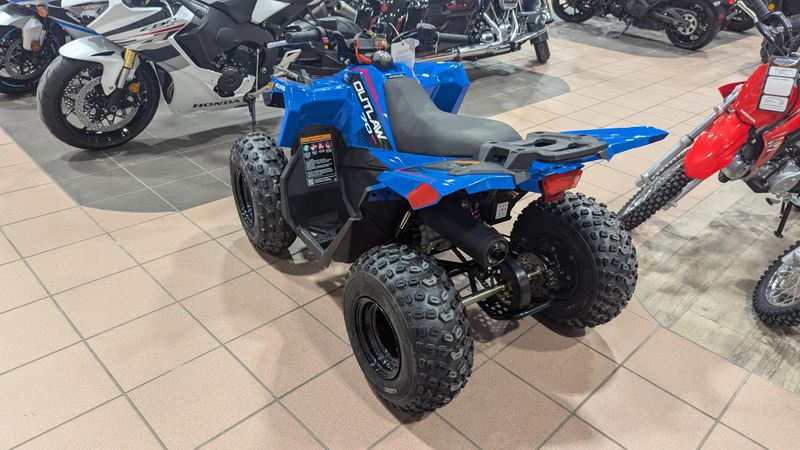 2025 POLARIS OUTLAW 70 EFI  VELOCITY BLUE AND FIERCE FUCHSIA in a VELOCITY BLUE AND FIERCE FUCHSIA exterior color. Family PowerSports (877) 886-1997 familypowersports.com 