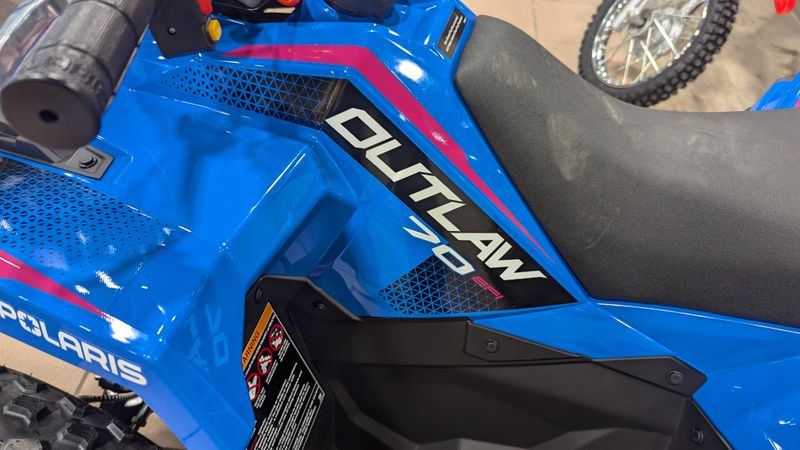 2025 POLARIS OUTLAW 70 EFI  VELOCITY BLUE AND FIERCE FUCHSIA in a VELOCITY BLUE AND FIERCE FUCHSIA exterior color. Family PowerSports (877) 886-1997 familypowersports.com 