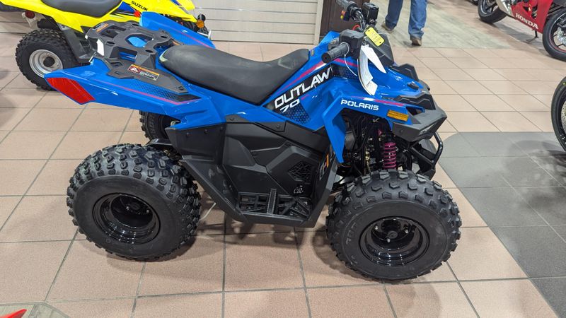 2025 POLARIS OUTLAW 70 EFI  VELOCITY BLUE AND FIERCE FUCHSIA in a VELOCITY BLUE AND FIERCE FUCHSIA exterior color. Family PowerSports (877) 886-1997 familypowersports.com 