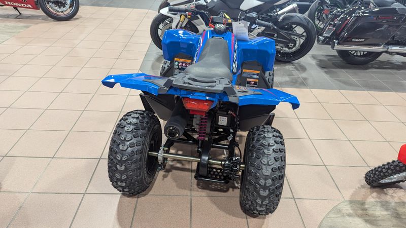 2025 POLARIS OUTLAW 70 EFI  VELOCITY BLUE AND FIERCE FUCHSIA in a VELOCITY BLUE AND FIERCE FUCHSIA exterior color. Family PowerSports (877) 886-1997 familypowersports.com 