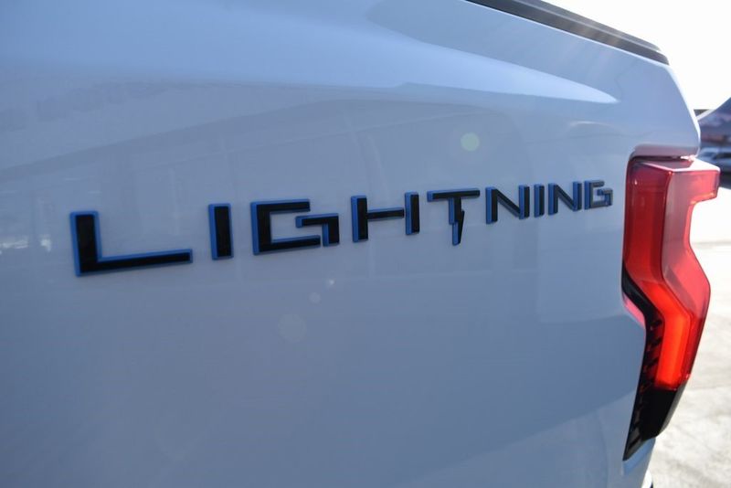 2023 Ford F-150 Lightning Lariat in a Star White Metallic Tri Coat exterior color and Blackinterior. BEACH BLVD OF CARS beachblvdofcars.com 