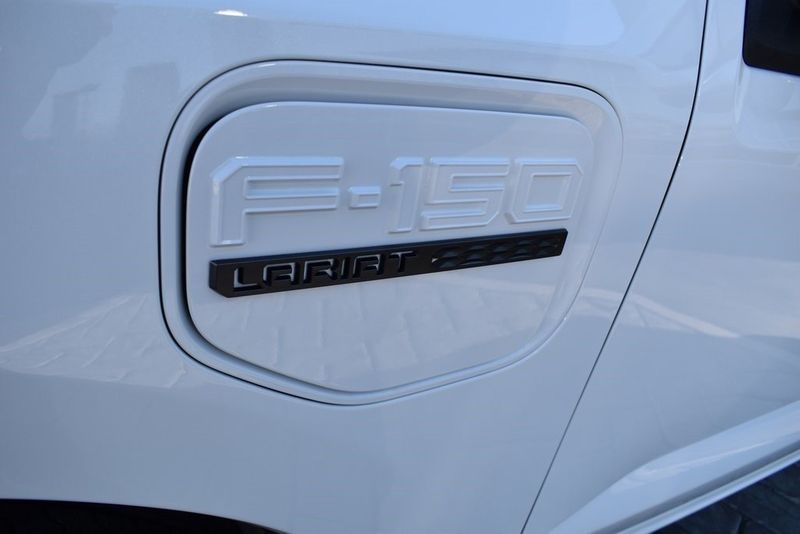 2023 Ford F-150 Lightning Lariat in a Star White Metallic Tri Coat exterior color and Blackinterior. BEACH BLVD OF CARS beachblvdofcars.com 
