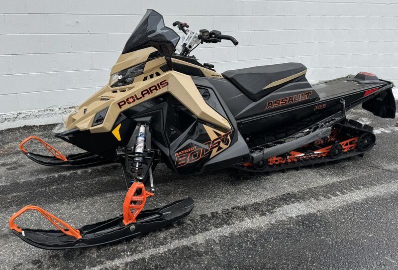 2024 Polaris Switchback Assault in a Gloss Black/Military Tan/Orange Burst exterior color. New England Powersports 978 338-8990 pixelmotiondemo.com 