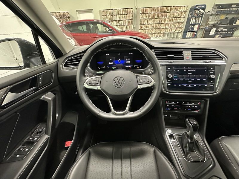2023 Volkswagen Tiguan SE w/Sunroof & 3rd Row in a Deep Black Pearl exterior color and Black Heated Seatsinterior. Schmelz Countryside Alfa Romeo (651) 867-3222 schmelzalfaromeo.com 