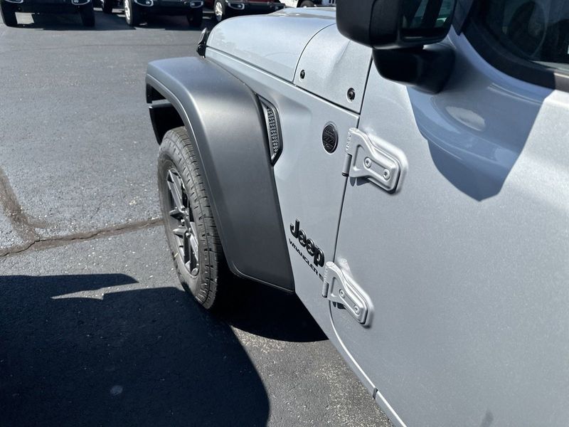 2024 Jeep Wrangler 4-door Sport S in a Silver Zynith Clear Coat exterior color and Blackinterior. CDJR of Anytown 949-555-4321 pixelmotiondemo.com 