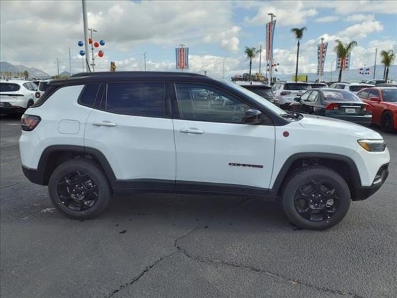 2024 Jeep Compass Trailhawk in a Bright White Clear Coat exterior color and Ruby Red/Blackinterior. Perris Valley Auto Center 951-657-6100 perrisvalleyautocenter.com 