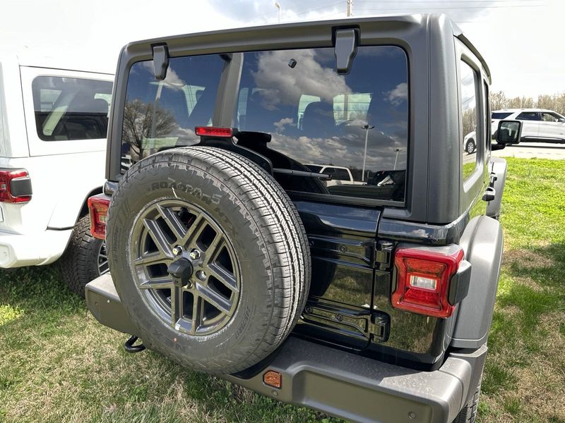 2024 Jeep Wrangler 4-door Sport S in a Black Clear Coat exterior color and Blackinterior. CDJR of Anytown 949-555-4321 pixelmotiondemo.com 