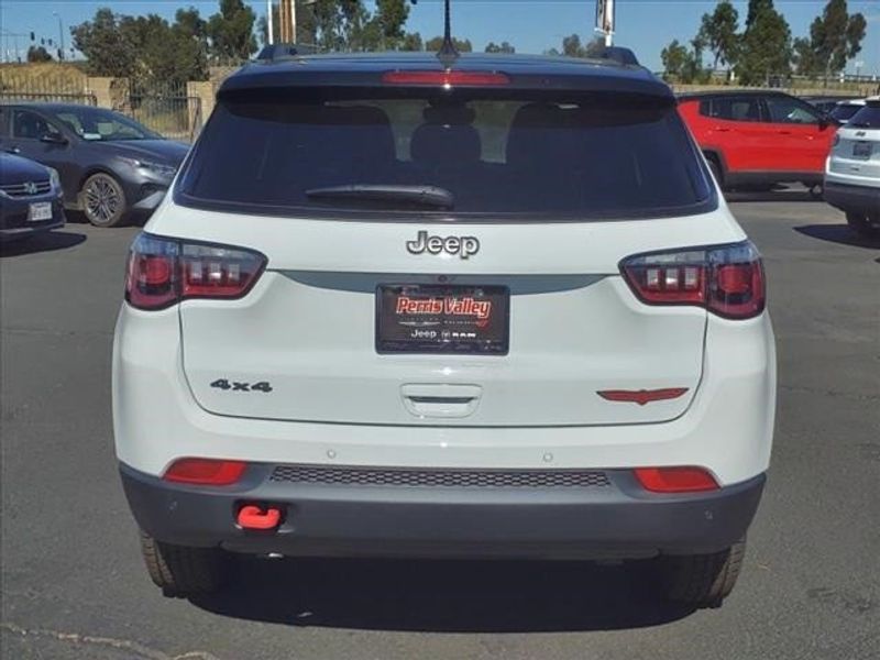 2024 Jeep Compass Trailhawk in a Bright White Clear Coat exterior color and Ruby Red/Blackinterior. Perris Valley Auto Center 951-657-6100 perrisvalleyautocenter.com 