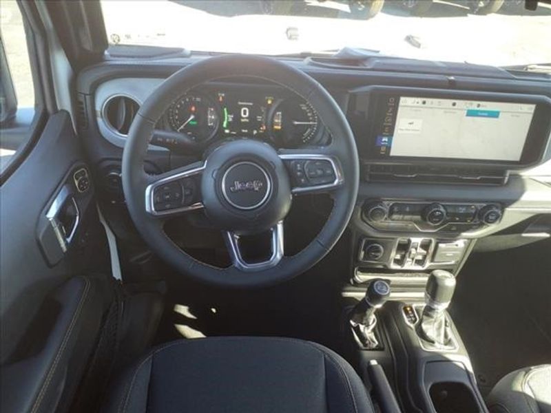 2024 Jeep Wrangler Sahara 4xe in a Bright White Clear Coat exterior color and Blackinterior. Perris Valley Auto Center 951-657-6100 perrisvalleyautocenter.com 