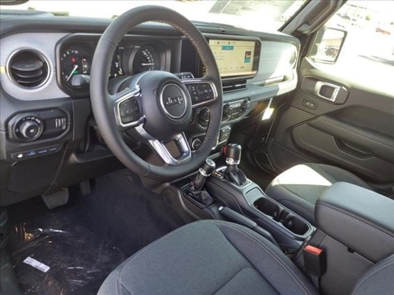 2024 Jeep Wrangler Sahara 4xe in a Black Clear Coat exterior color and Blackinterior. Perris Valley Auto Center 951-657-6100 perrisvalleyautocenter.com 