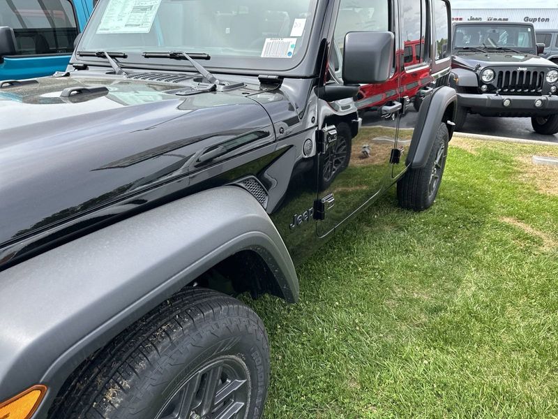 2024 Jeep Wrangler 4-door Sport S in a Black Clear Coat exterior color and Blackinterior. CDJR of Anytown 949-555-4321 pixelmotiondemo.com 