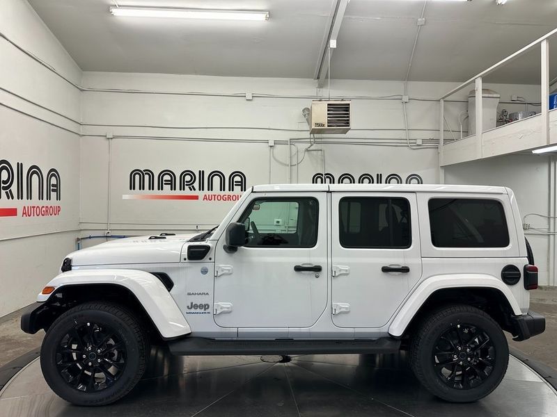 2024 Jeep Wrangler 4-door Sahara 4xe in a Bright White Clear Coat exterior color. Marina Auto Group (855) 564-8688 marinaautogroup.com 