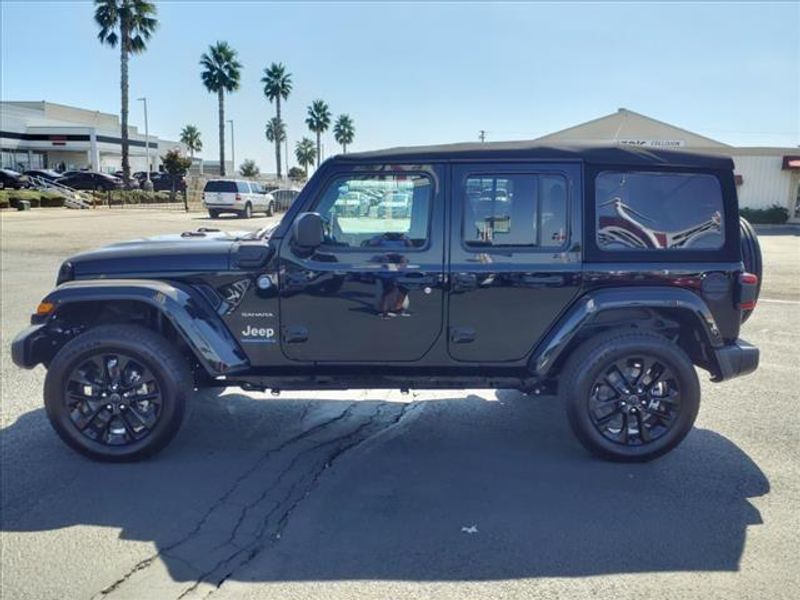 2024 Jeep Wrangler Sahara 4xe in a Black Clear Coat exterior color and Blackinterior. Perris Valley Auto Center 951-657-6100 perrisvalleyautocenter.com 