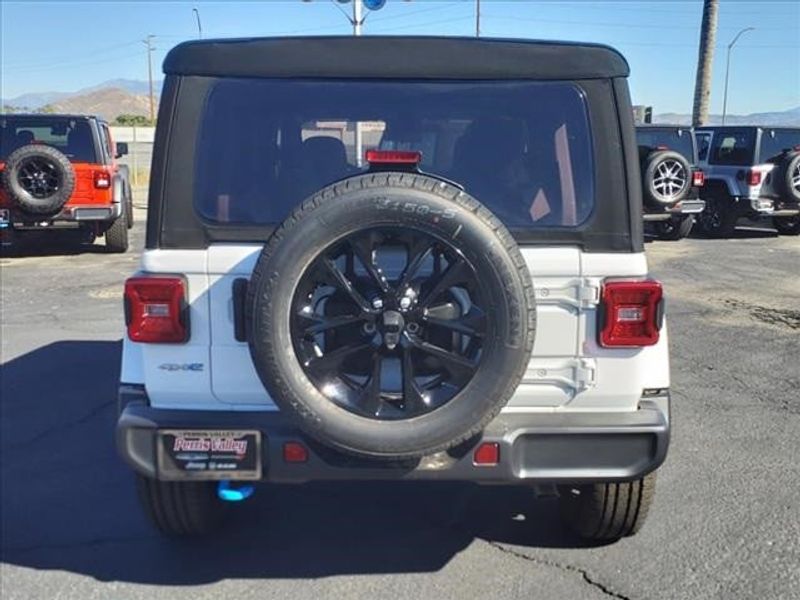 2024 Jeep Wrangler Sahara 4xe in a Bright White Clear Coat exterior color and Blackinterior. Perris Valley Auto Center 951-657-6100 perrisvalleyautocenter.com 