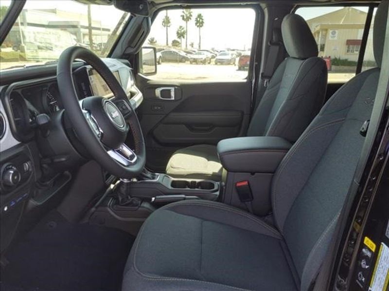 2024 Jeep Wrangler Sahara 4xe in a Black Clear Coat exterior color and Blackinterior. Perris Valley Auto Center 951-657-6100 perrisvalleyautocenter.com 