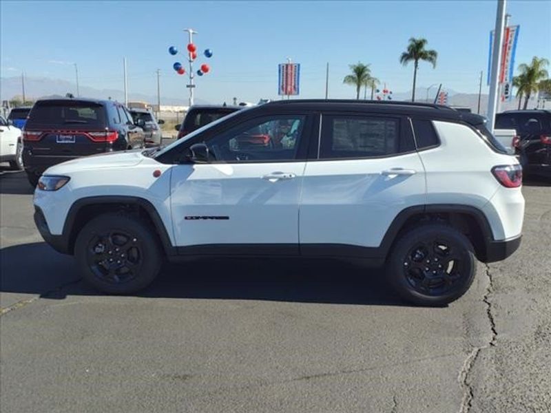 2024 Jeep Compass Trailhawk in a Bright White Clear Coat exterior color and Ruby Red/Blackinterior. Perris Valley Auto Center 951-657-6100 perrisvalleyautocenter.com 