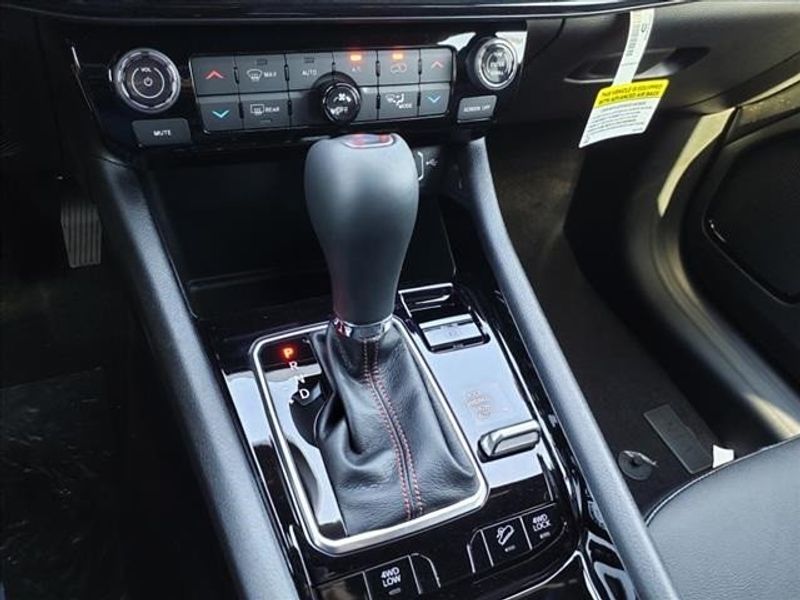 2024 Jeep Compass Trailhawk in a Bright White Clear Coat exterior color and Ruby Red/Blackinterior. Perris Valley Auto Center 951-657-6100 perrisvalleyautocenter.com 