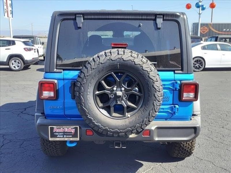 2024 Jeep Wrangler 4-door Willys 4xe in a Hydro Blue Pearl Coat exterior color and Blackinterior. Perris Valley Chrysler Dodge Jeep Ram 951-355-1970 perrisvalleydodgejeepchrysler.com 