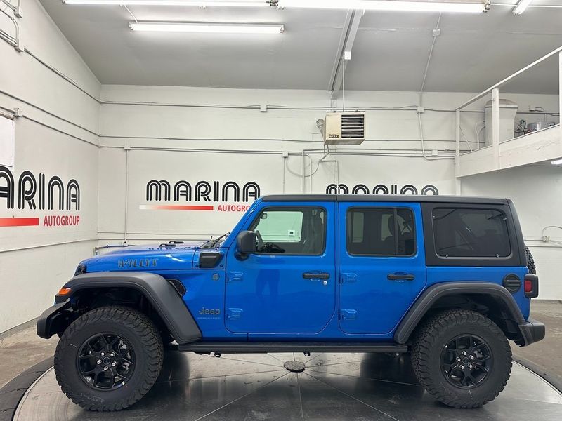 2024 Jeep Wrangler 4-door Willys 4xe in a Hydro Blue Pearl Coat exterior color and Blackinterior. Marina Auto Group (855) 564-8688 marinaautogroup.com 