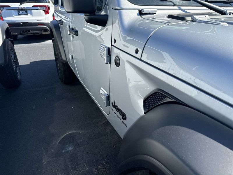 2024 Jeep Wrangler 4-door Sport S in a Silver Zynith Clear Coat exterior color and Blackinterior. CDJR of Anytown 949-555-4321 pixelmotiondemo.com 