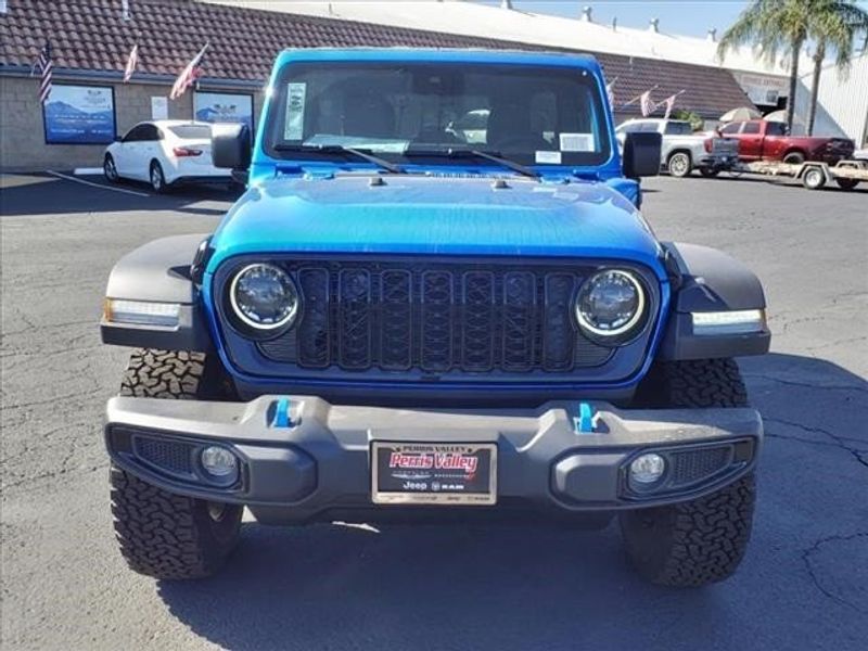 2024 Jeep Wrangler Willys 4xe in a Hydro Blue Pearl Coat exterior color and Blackinterior. Perris Valley Auto Center 951-657-6100 perrisvalleyautocenter.com 