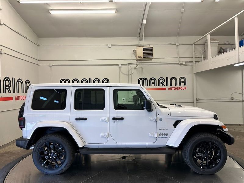 2024 Jeep Wrangler 4-door Sahara 4xe in a Bright White Clear Coat exterior color. Marina Auto Group (855) 564-8688 marinaautogroup.com 