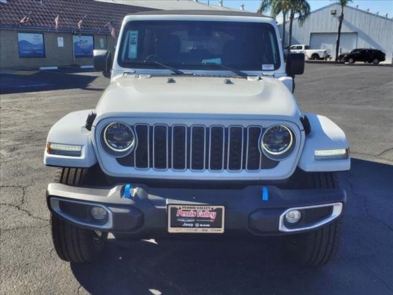 2024 Jeep Wrangler Sahara 4xe in a Bright White Clear Coat exterior color and Blackinterior. Perris Valley Auto Center 951-657-6100 perrisvalleyautocenter.com 