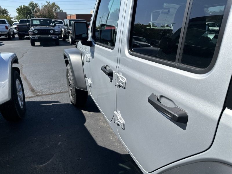 2024 Jeep Wrangler 4-door Sport S in a Silver Zynith Clear Coat exterior color and Blackinterior. CDJR of Anytown 949-555-4321 pixelmotiondemo.com 