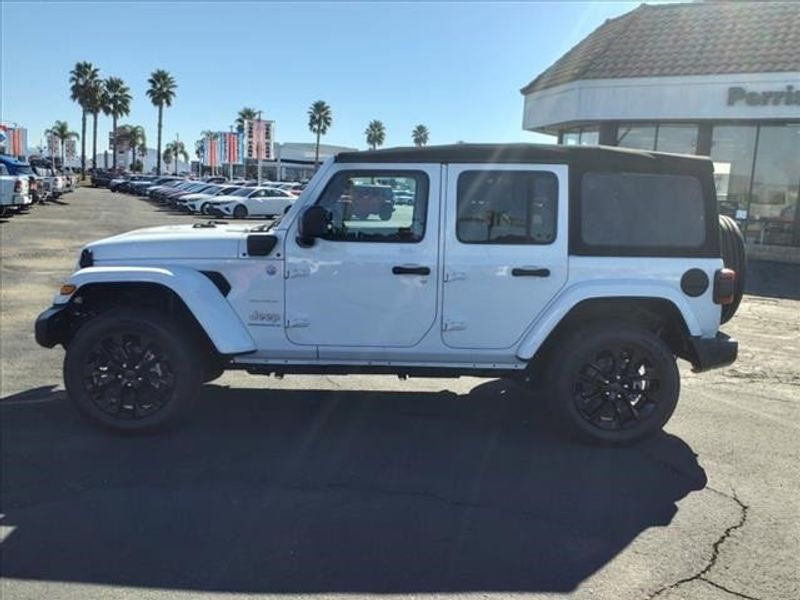 2024 Jeep Wrangler Sahara 4xe in a Bright White Clear Coat exterior color and Blackinterior. Perris Valley Auto Center 951-657-6100 perrisvalleyautocenter.com 