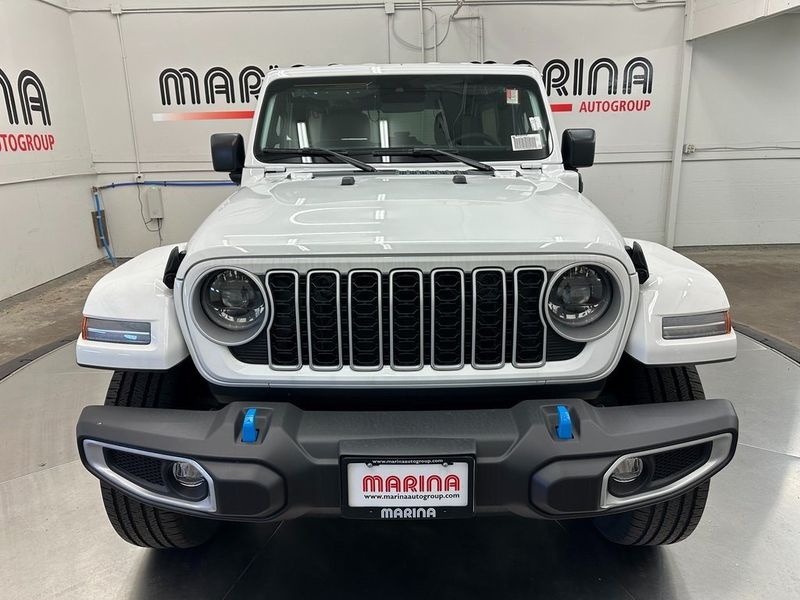 2024 Jeep Wrangler 4-door Sahara 4xe in a Bright White Clear Coat exterior color. Marina Auto Group (855) 564-8688 marinaautogroup.com 