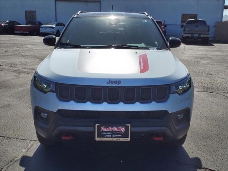 2024 Jeep Compass Trailhawk in a Bright White Clear Coat exterior color and Ruby Red/Blackinterior. Perris Valley Auto Center 951-657-6100 perrisvalleyautocenter.com 