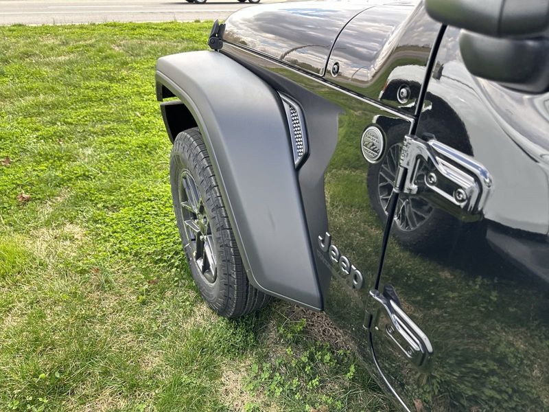 2024 Jeep Wrangler 4-door Sport S in a Black Clear Coat exterior color and Blackinterior. CDJR of Anytown 949-555-4321 pixelmotiondemo.com 