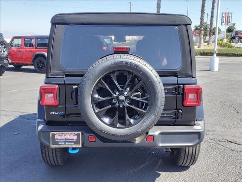 2024 Jeep Wrangler Sahara 4xe in a Black Clear Coat exterior color and Blackinterior. Perris Valley Auto Center 951-657-6100 perrisvalleyautocenter.com 