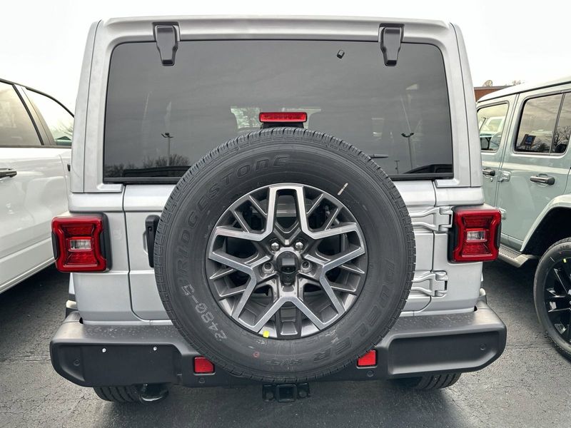 2024 Jeep Wrangler 4-door Sahara in a Silver Zynith Clear Coat exterior color and Blackinterior. CDJR of Anytown 949-555-4321 pixelmotiondemo.com 